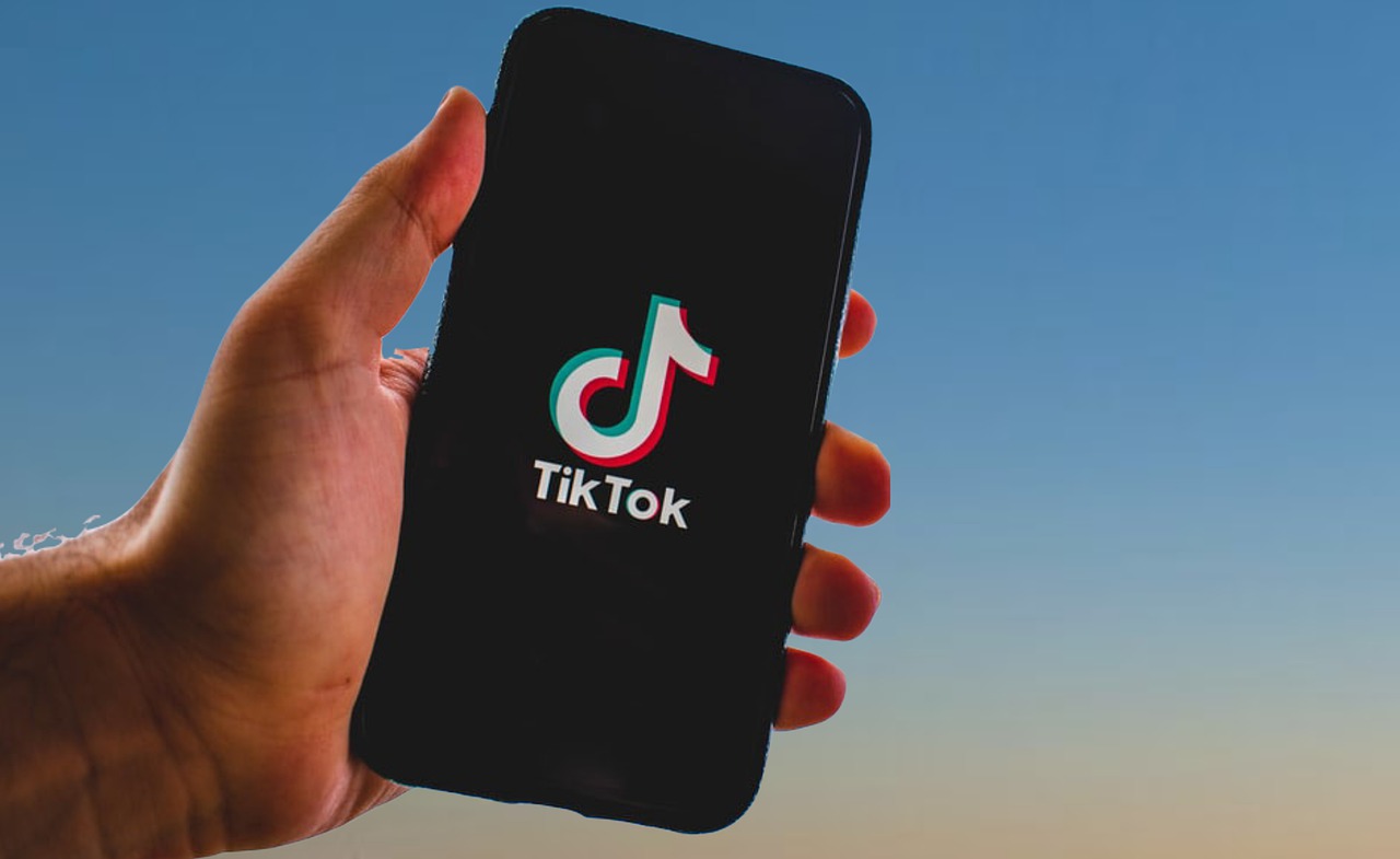 Uma mão segura um celular com o app do TikTok aberto. 
